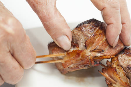 Taking off the toothpicks from the cooked filet mignonの写真素材