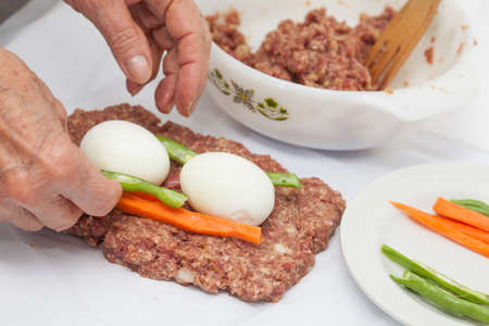 Preparing and filling the Egg and Vegetables stuffed meatloafの写真素材