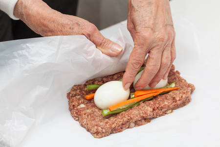Rolling up the Egg and Vegetables stuffed meatloafの写真素材