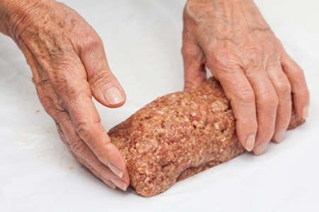 shaping a raw egg and vegetables stuffed meatloafの写真素材
