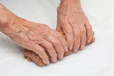 shaping a raw egg and vegetables stuffed meatloaf