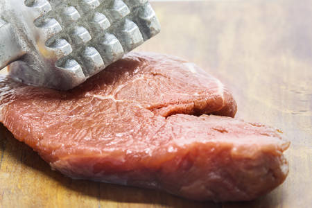 Close up of raw beef meat and hammerの写真素材