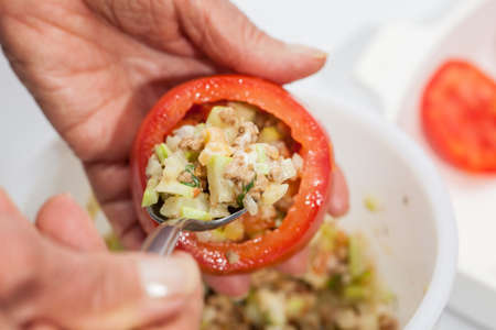 Stuffed tomatoes preparation : Stuffing the emptied tomatoesの写真素材