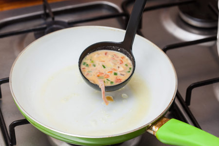 Omelet preparation : Pouring the omelet mix onto a pan