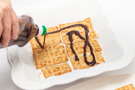 Napoleon dessert preparation : Adding chocolate sauce over the cookiesの写真素材