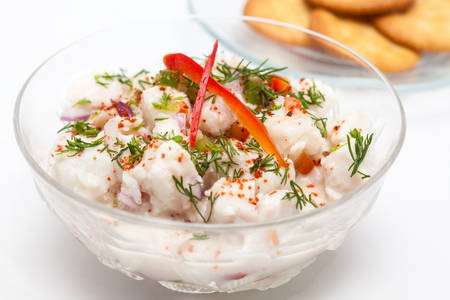 Peruvian ceviche preparation : White fish Peruvian ceviche served in a transparent bowl with crackersの写真素材