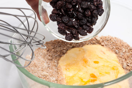 Wheat bran muffins preparation : Adding raisins to the mix to prepare integral wheat bran muffins