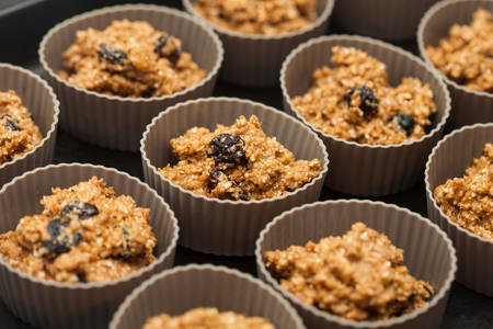Wheat bran muffins preparation : Adding wheat bran muffins mix to the baking cupsの写真素材