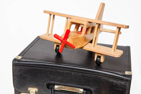 Travel concept : retro style suitcase and biplane on white backgroundの写真素材