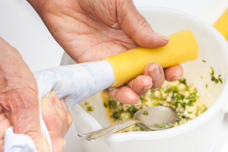 Spinach and cheese cannelloni preparation : Stuffing the cannelloni with the spinach and cheese fillingの写真素材