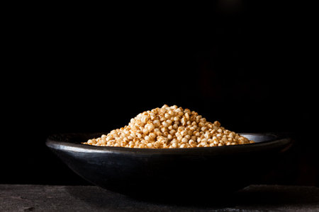 Puffed quinoa seeds (Chenopodium quinoa) in a traditional black clay dishの写真素材