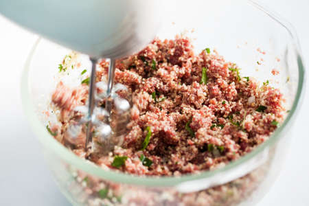 Step by step Levantine cuisine kibbeh preparation : Mixing the ingredients to prepare kibbeh into a bowlの写真素材
