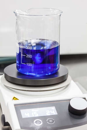 Glass beaker on top of a magnetic laboratory stirrerの写真素材