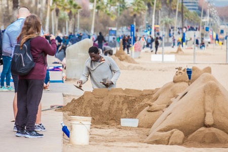 Sand sculptor working at La Barceloneta Beach in Barcelona Spainのeditorial素材