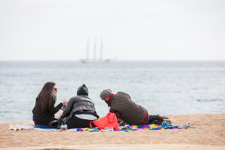 Group of people at La Barceloneta Beach in winterのeditorial素材