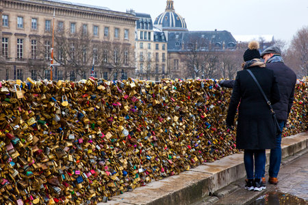 Couple watching the love locks at Pont Neuf in Parisのeditorial素材