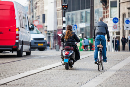 Cyclist in a cold early spring day at the Old Central district of Amsterdamのeditorial素材