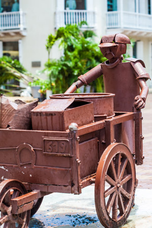 Sculpture of a man with a traditional wheelbarrow at the San Pedro Claver square in Cartagena de Indiasのeditorial素材