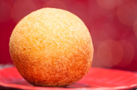 Traditional Colombian bunuelos (Deep Fried Cheese Bread) on christmas red background