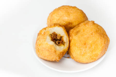 Preparation steps of traditional Colombian dish called stuffed potatoes : Ready stuffed potatoes served in a white ceramic dish isolated on white backgroundの写真素材