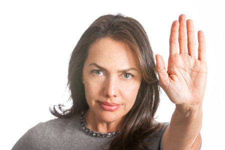 Woman with outstretched hand showing stop gesture isolated on white background
