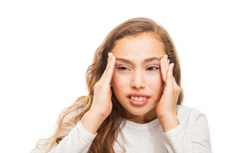 Young girl suffering from headache desperate and stressed because of pain and migraine with hands on head isolated on white backgroundの写真素材