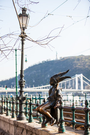 The famous Little Princess statue created by Laszlo Marton sitting on the railings of the Danube promenade in Budapestのeditorial素材