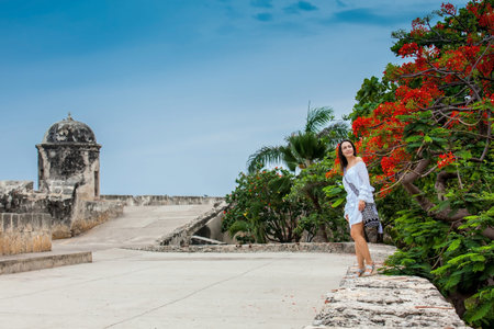 Beautiful woman on white dress walking alone at the walls surrounding the colonial city of Cartagena...