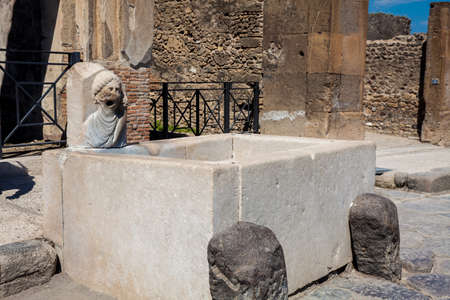 Antique water fountain on the streets of the ancient city of Pompeiiの写真素材