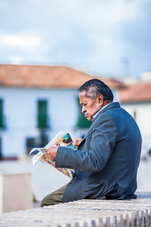Senior man reading a newspaper at the Bolivar Square in Tunja cityのeditorial素材