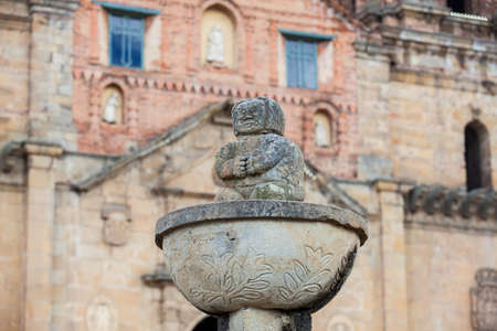 Detail of the antique fountain at the central square in the small town of Mongui with the historical Basilica of Our Lady of Mongui on backgroundの写真素材