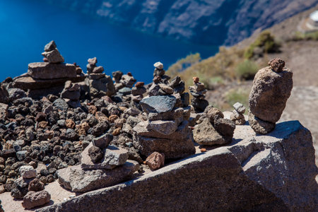 Cairns of rocks at the walking path number 9 between the cities of Fira and Oia at Santorini Islandの写真素材