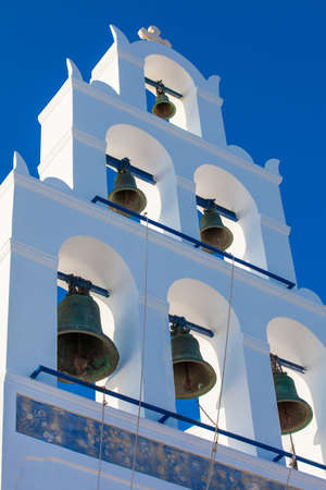 Bell tower of the Church of Panagia Platsani located in Oia city at Santorini Island in a beautiful early spring dayの写真素材