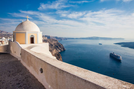 The Aegean sea and the Catholic Church of St. Stylianos in the city of Fira in Santorini Islandの写真素材
