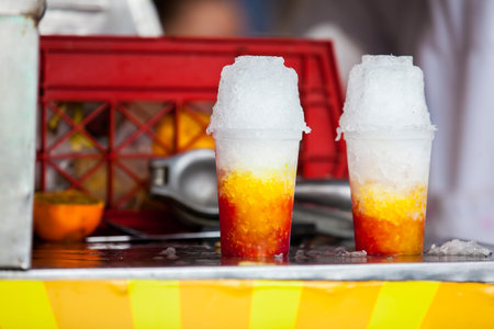 Street vendor in the city of Cali in Colombia preparing and selling a traditional sweet water ice called choladoの写真素材