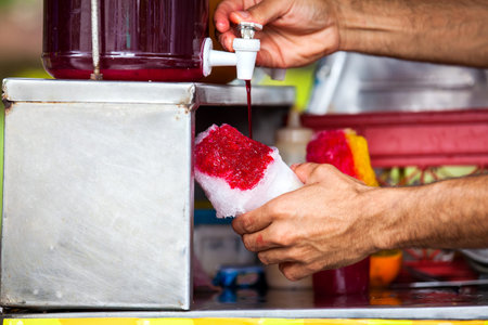 Street vendor in the city of Cali in Colombia preparing and selling a traditional sweet water ice...