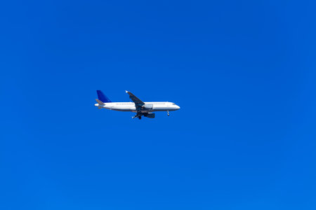Comercial airplane flying in a beautiful blue sky day