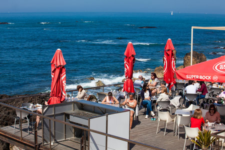 PORTO, PORTUGAL - MAY, 2018: Tourists and locals enjoying an early spring day at the beautiful beaches of Porto coastlineのeditorial素材