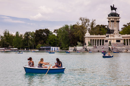 MADRID, SPAIN - MAY, 2018: Tourists and locals enjoying a beautiful spring day sailing at the Retiro Park pondのeditorial素材