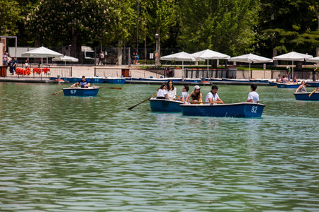 MADRID, SPAIN - MAY, 2018: Tourists and locals enjoying a beautiful spring day sailing at the Retiro...