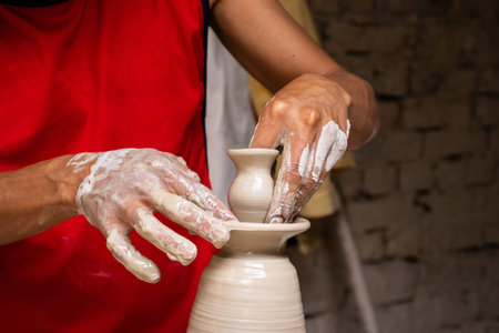 Man making ceramic articles on the potters wheel in a traditional factory in the city of RÃ¡quira...
