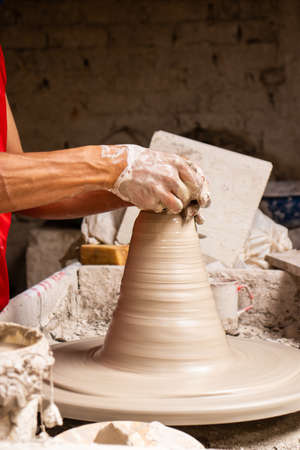 Man making ceramic articles on the potters wheel in a traditional factory in the city of RÃ¡quira located in the department of Cundinamarca in Colombiaの写真素材