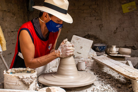 RAQUIRA, COLOMBIA - FEBRUARY 2021. Man making ceramic articles on the potters wheel in a traditional factory in the city of RÃ¡quira located in the department of Cundinamarca in Colombiaのeditorial素材