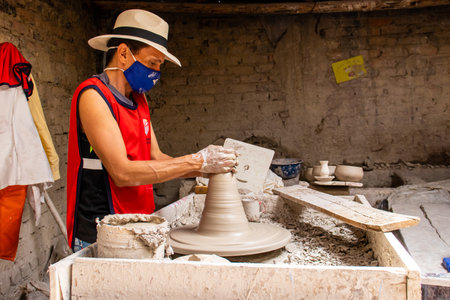 RAQUIRA, COLOMBIA - FEBRUARY 2021. Man making ceramic articles on the potters wheel in a traditional factory in the city of RÃ¡quira located in the department of Cundinamarca in Colombiaのeditorial素材