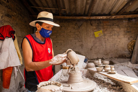 RAQUIRA, COLOMBIA - FEBRUARY 2021. Man making ceramic articles on the potters wheel in a traditional...
