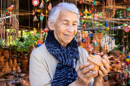 Senior woman buying pottery at a traditional ceramics factory in the city of Raquira. City of Potsの写真素材