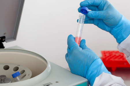 Scientist inserting a tube in a laboratory centrifugeの写真素材