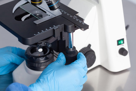 Young female scientist looking at samples under the microscope