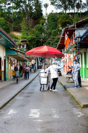 SALENTO, COLOMBIA - JULY 2021. Street vendor of traditional aborrajados walking along the Real Street in the beautiful small town of Salentoのeditorial素材