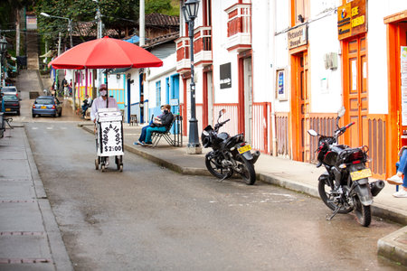 SALENTO, COLOMBIA - JULY 2021. Street vendor of traditional aborrajados walking along the Real Street in the beautiful small town of Salentoのeditorial素材
